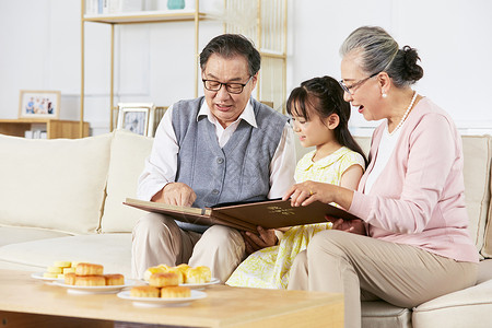 小女孩中秋节和爷爷奶奶翻看相册老人高清图片素材