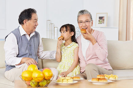 吃月饼的小女孩小女孩和爷爷奶奶中秋节一起吃月饼背景
