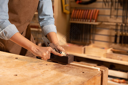 木工工人工匠用刨子削木头特写背景