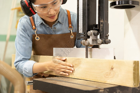 女性工匠用切割机锯木头图片