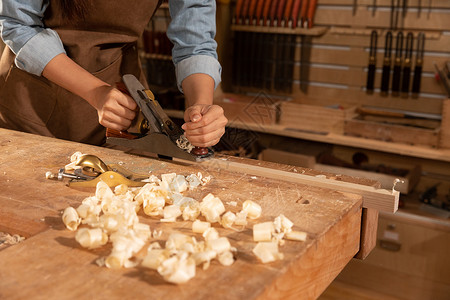 工匠用刨子削木头图片