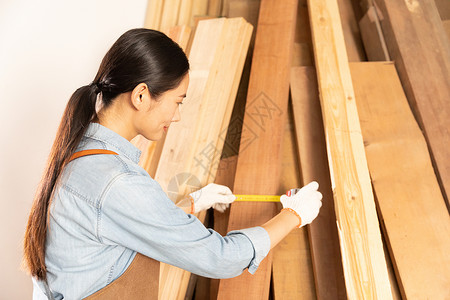 女性工匠测量木材物料图片