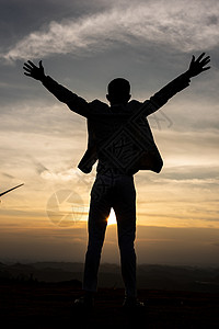 夕阳下跳跃的人夕阳下男性剪影背景