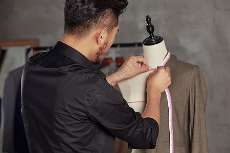 服装设计师在工作室测量服装尺码高清图片