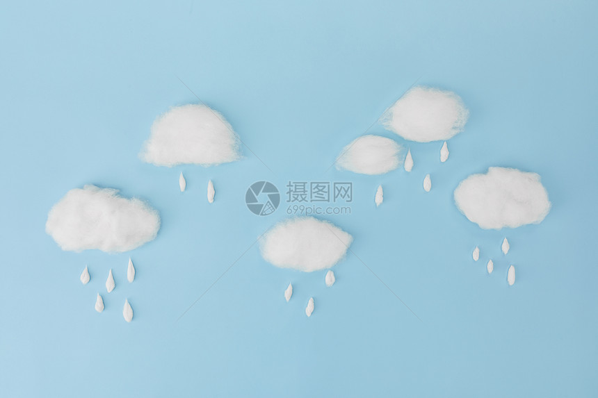 蓝色背景上的棉花下雨创意图图片