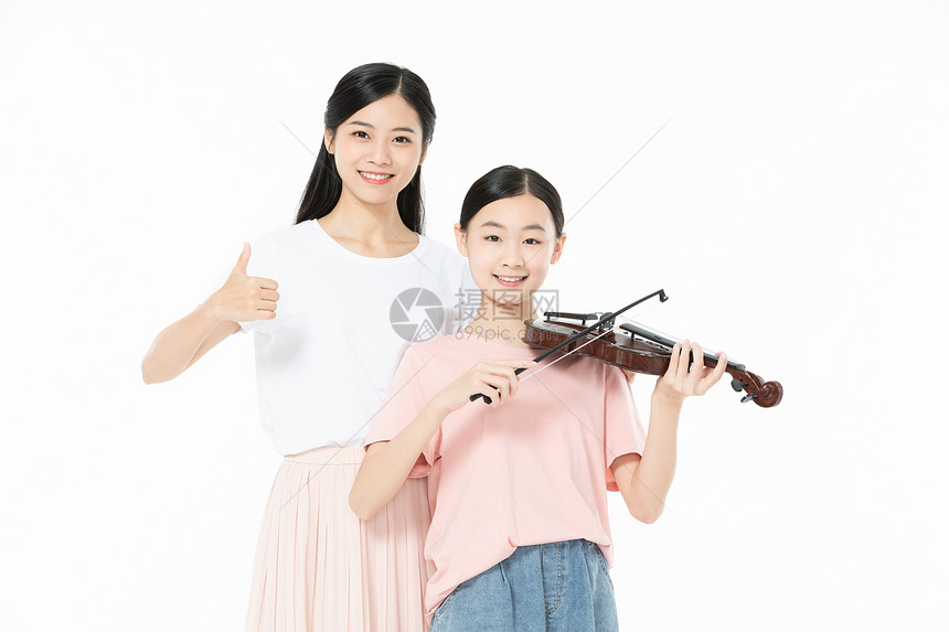 老师教青少年学生拉小提琴图片