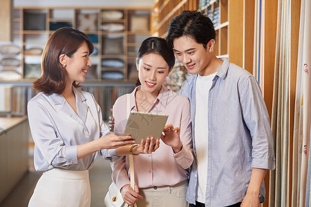 图书馆介绍展架女设计师向年轻夫妻介绍窗帘设计背景