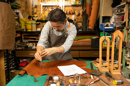 男性皮匠修剪切割皮料工匠高清图片素材
