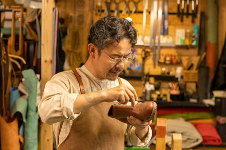 男性皮匠修理皮鞋亚洲人高清图片素材