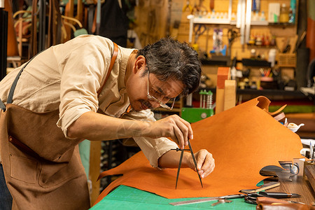 男性皮匠切割皮料工人高清图片素材
