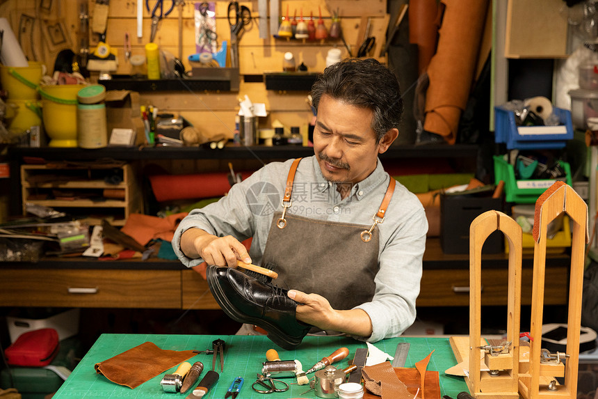 中年男性鞋匠保养皮鞋图片