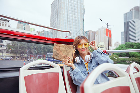 秋季旅行季年轻女孩手拿城市地图背景