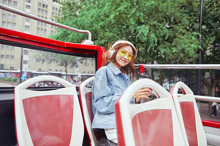 背对伸手女孩坐观光大巴旅游伸手欢呼的年轻女孩背景