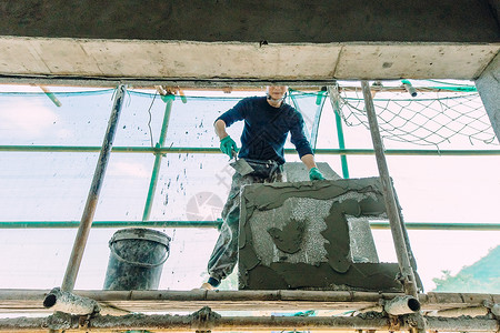 水泥工人正在做外墙施工的建筑工人背景