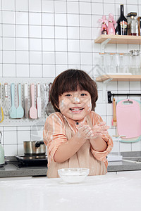 儿童小男孩在厨房撒面粉嬉戏背景图片