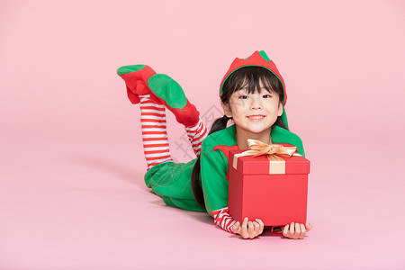 卡通恐龙时代可爱小女孩cos装扮过圣诞节拿礼物盒背景