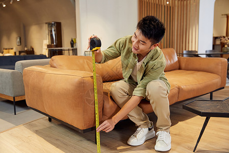 年轻男士测量沙发尺寸生活高清图片素材