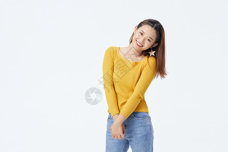 穿黄色毛衣自信微笑的长发美女图片