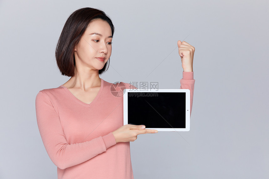 女性拿着平板展示手臂肌肉图片
