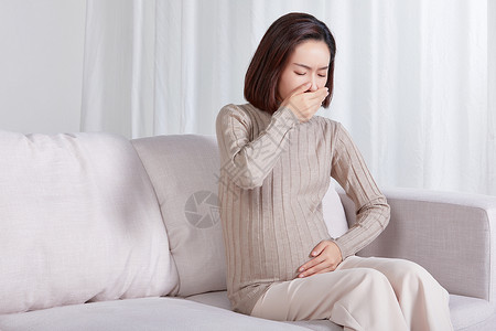 反应疾病孕妇一个人坐在沙发上反胃背景
