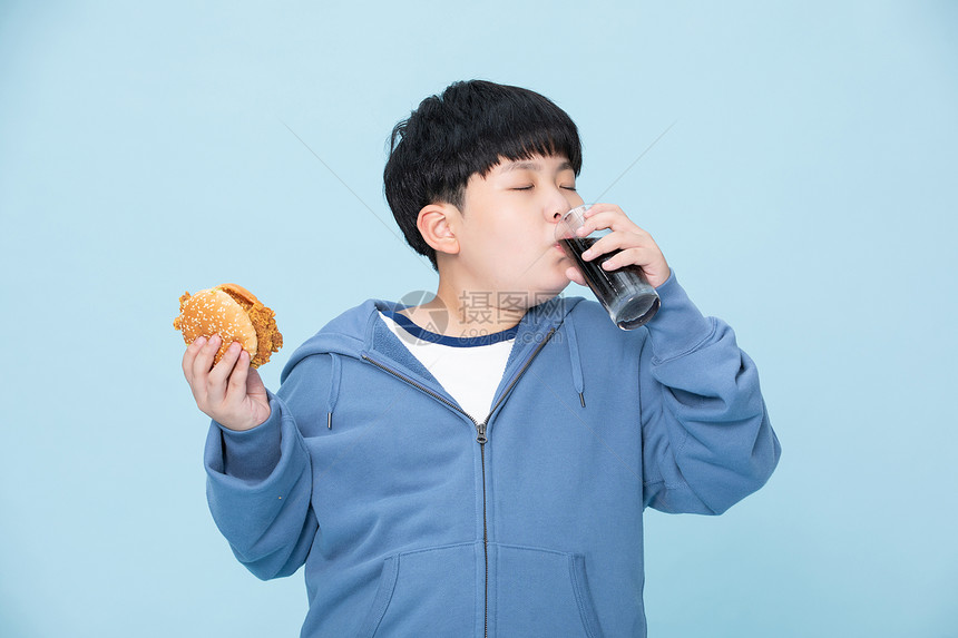 拿着汉堡喝可乐的小孩肥胖的男孩图片