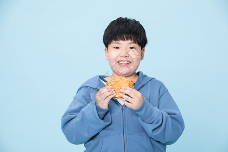 爱吃汉堡的男孩肥胖的小孩拿着食物图片