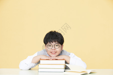 喜欢做作业的小男孩趴在书上喜欢看书的人背景图片