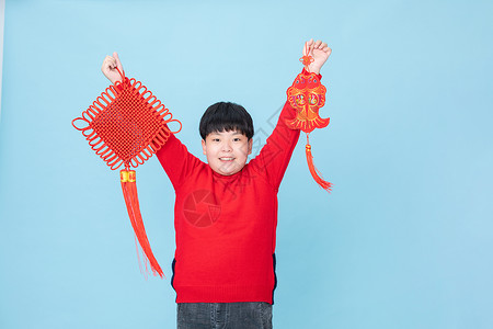 小男孩过春节拿着中国结和鱼图片