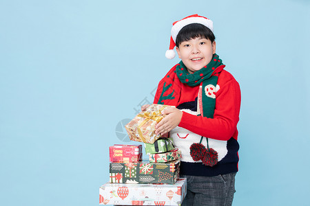 圣诞小男孩小男孩开心的拿着礼物盒背景