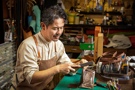 中年男性皮匠打磨皮具图片