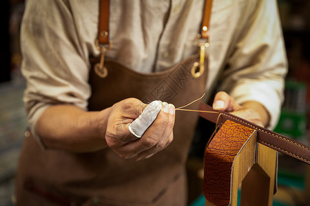 男性工匠手工制作皮带特写高清图片