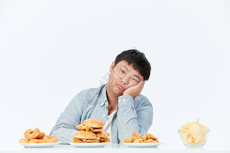 垃圾食品素材面对油炸食品食欲不振的小胖子背景