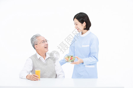 现榨橙汁护士给老人端来沙拉背景