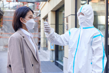 戴口罩的人疫情防护被测量体温的都市女性背景