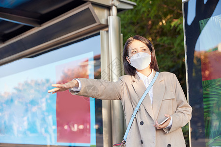 戴口罩公交站台打车的青年女生高清图片