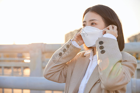 户外佩戴口罩防护的女性背景图片