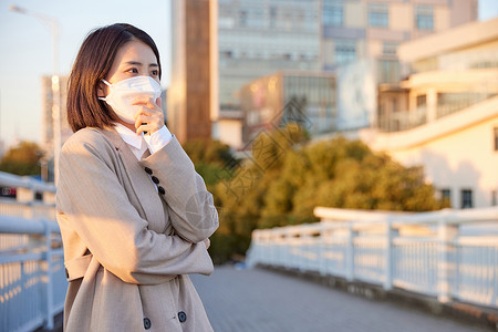 户外佩戴口罩防护的女性背景图片