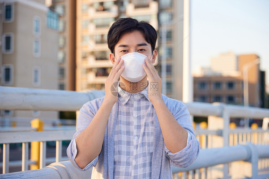 户外佩戴口罩的青年男性图片