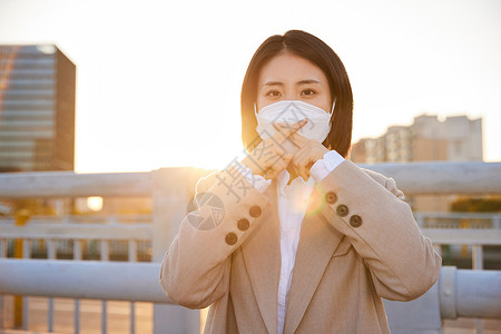 户外佩戴口罩的都市女性高清图片