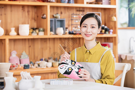 陶土美女匠人绘制脸谱背景