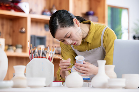 美女工匠绘制陶艺瓶图片