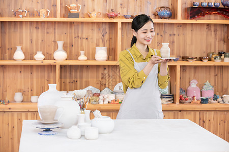 美女展示陶艺制品背景图片