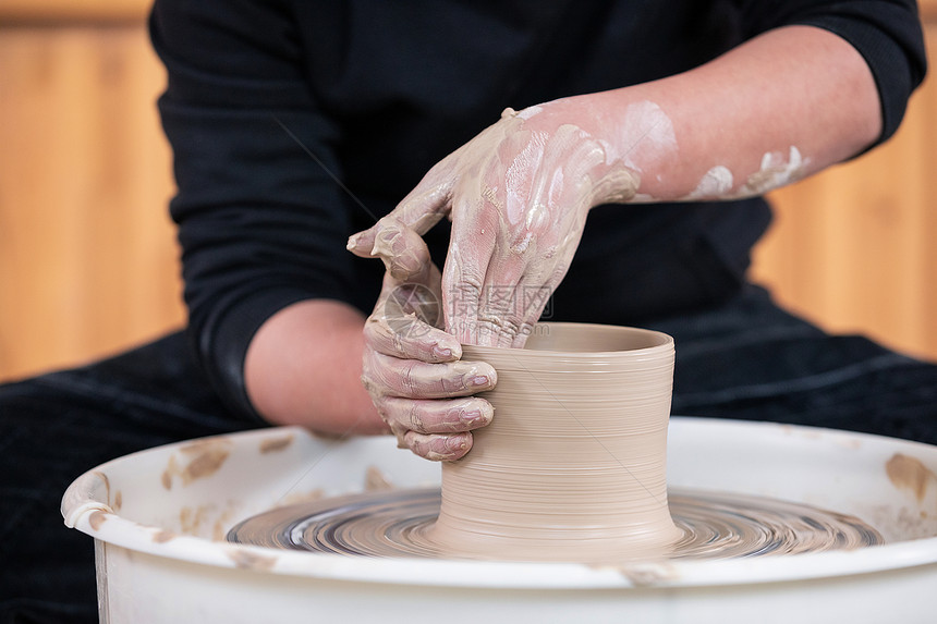 男性匠人手工制作陶艺制品特写图片