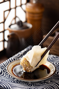 筷子夹着牛蛙筷子夹饺子蘸酱油醋背景