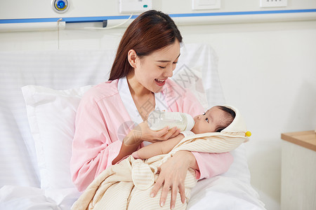 年轻妈妈给新生儿婴儿宝宝喂奶奶瓶高清图片素材