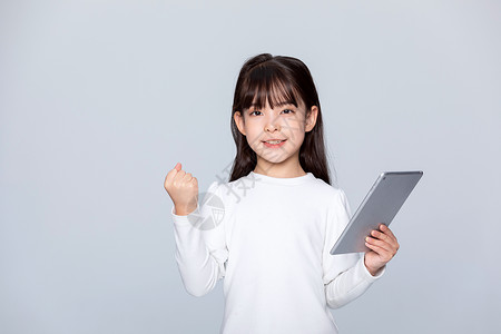 小女孩拿着平板电脑做加油动作背景图片