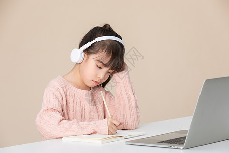 小女孩使用笔记本电脑做笔记思考图片