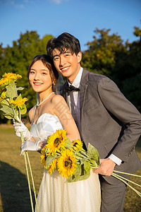 情侣写真摄影浪漫户外时尚情侣手拿向日葵背景