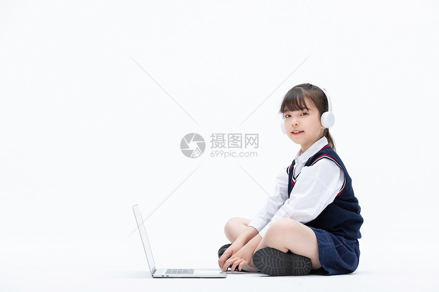 小女孩坐在地上使用笔记本电脑学习图片