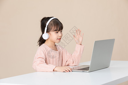 小女孩对着电脑屏幕打招呼图片素材